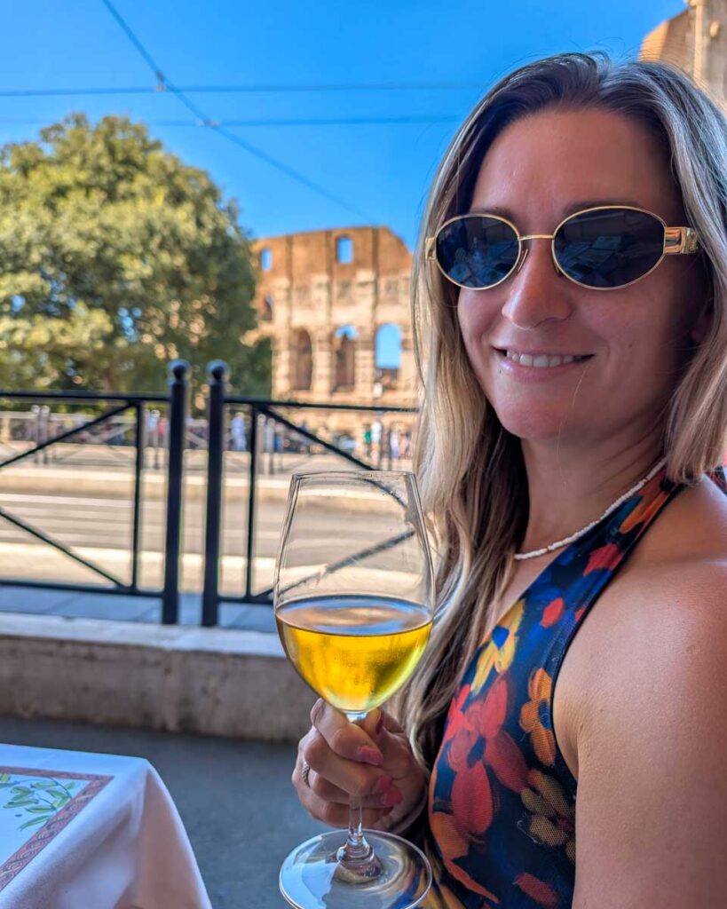 Bailey has wine with the Colosseum in the background in Rome Italy