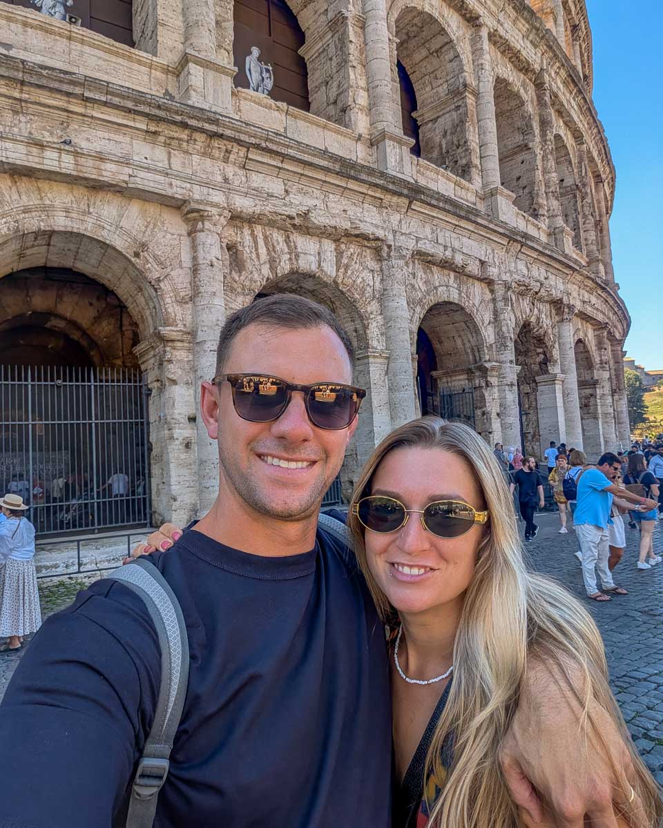Daniel and Bailey smile and pose at the Colosseum in Rome Italy