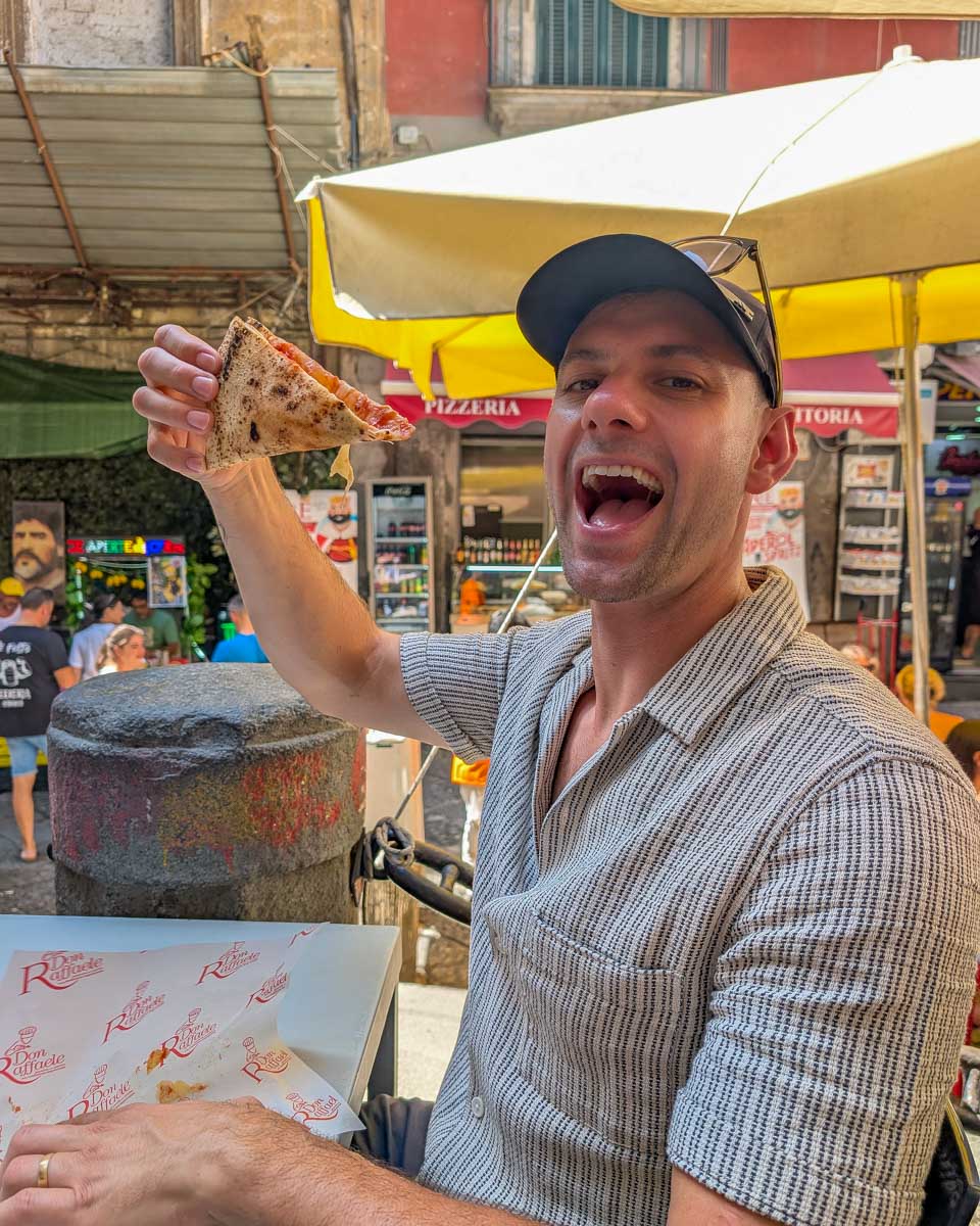 Daniel eating pizza on a food tour of Naples Italy