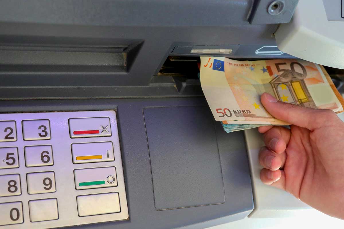 A person pulls money from an ATM in Europe