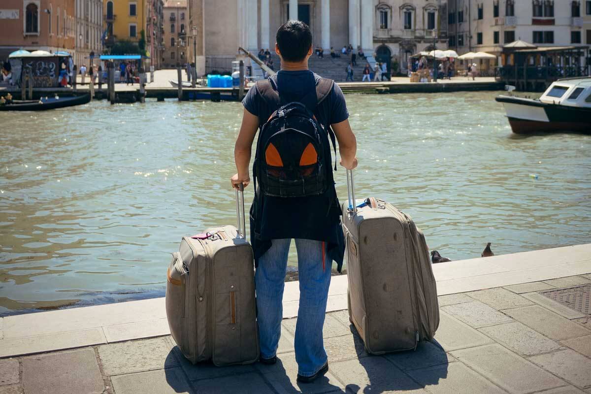 A man with large luggage in Venice