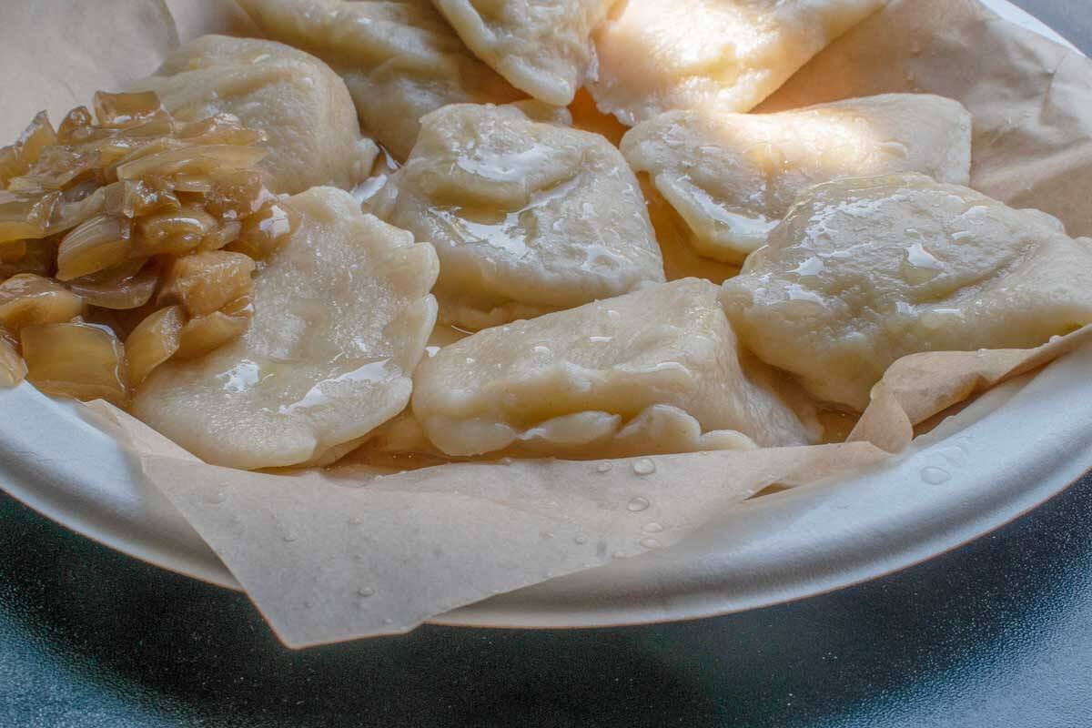 Authentic polish pierogi boiled and served with carmaleized onion in Poland