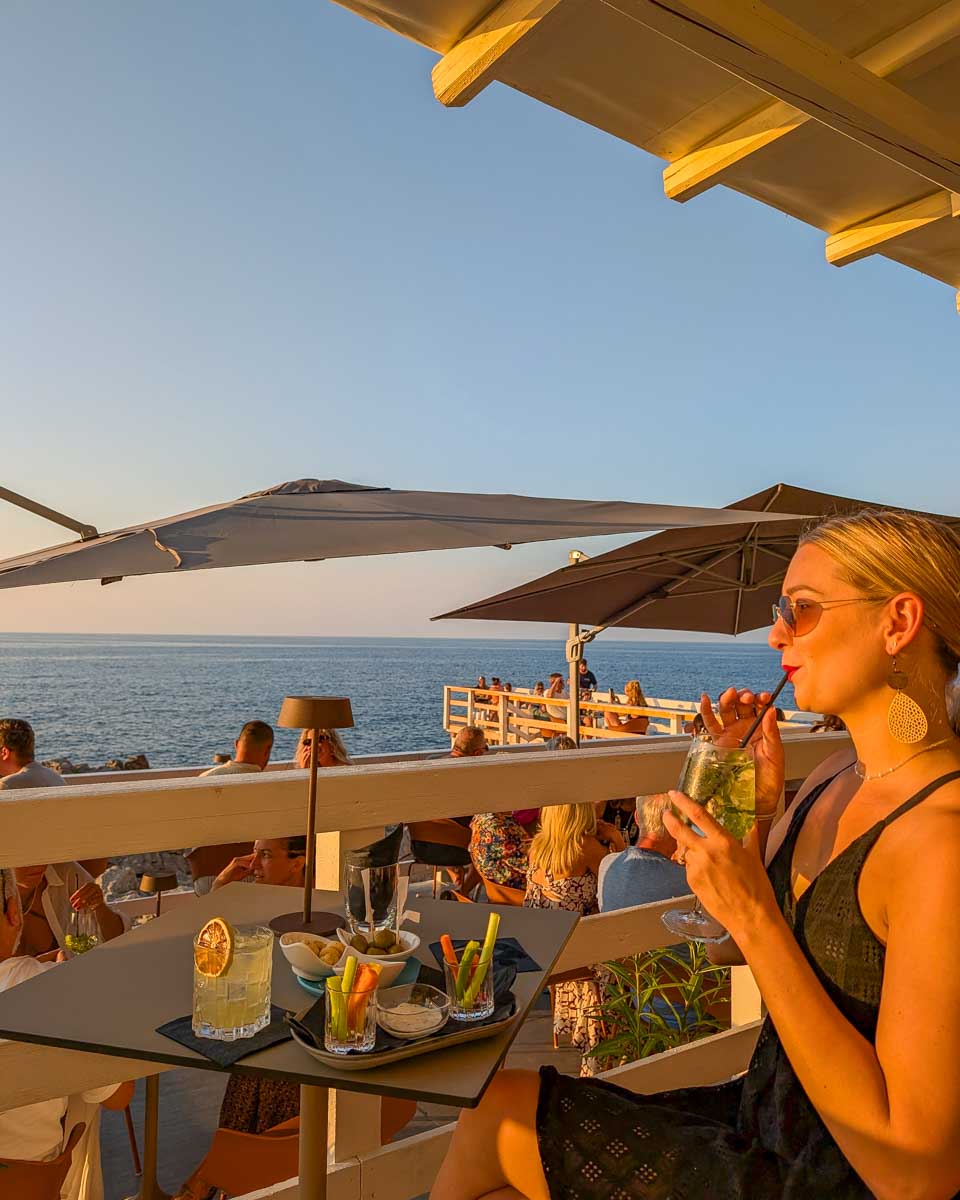 Bailey-drinks-aperitif-at-sunset-with-views-of-the-water-in Greece
