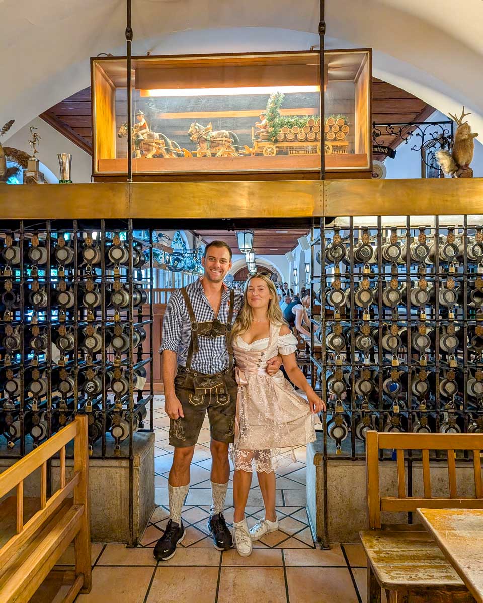 Daniel-and-Bailey-stand-in-a-bar-in-traditional-outfits-in-Munich-Germany during Oktoberfest