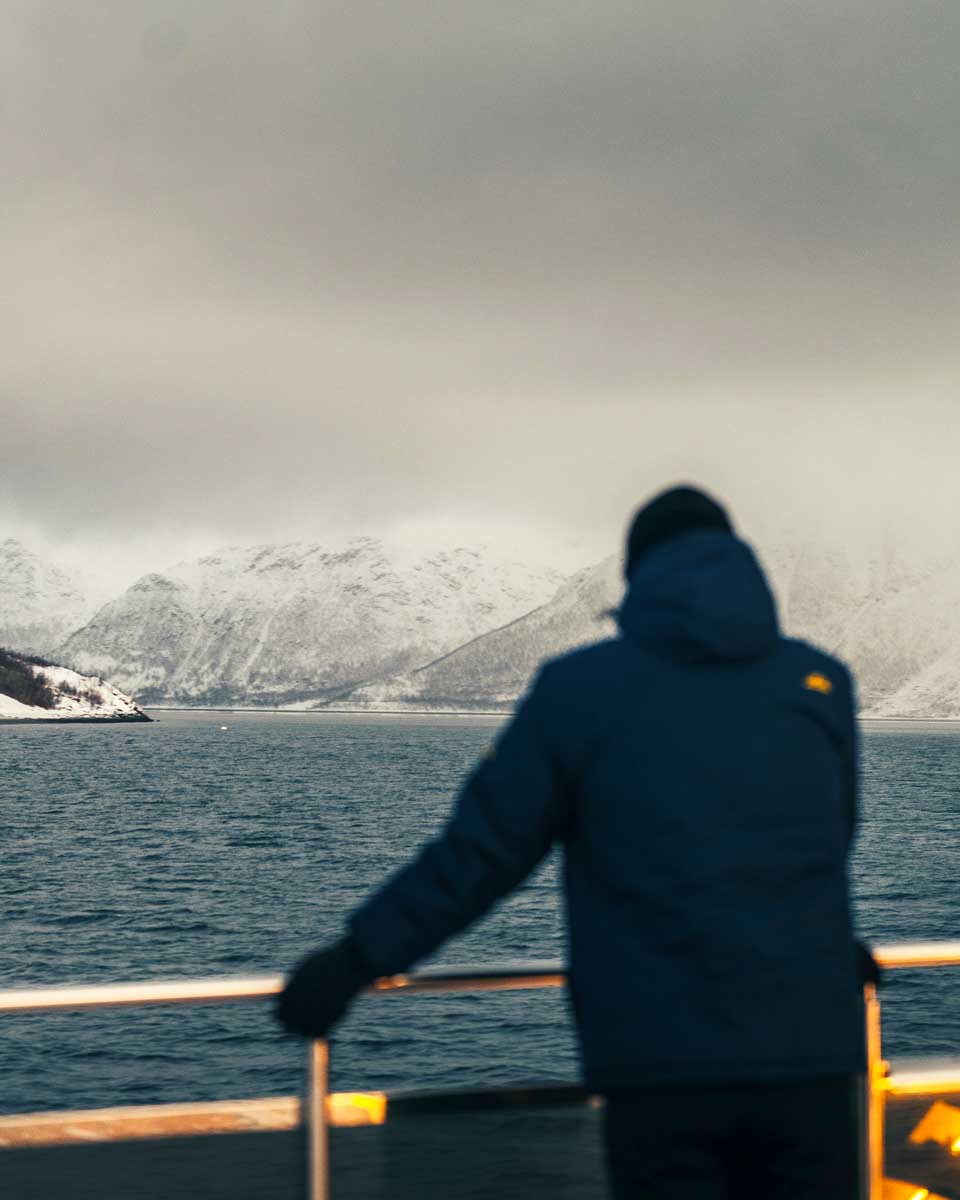 Daniel-looks-at-a-fjord-on-a-cruise-in-Tromso-Norway