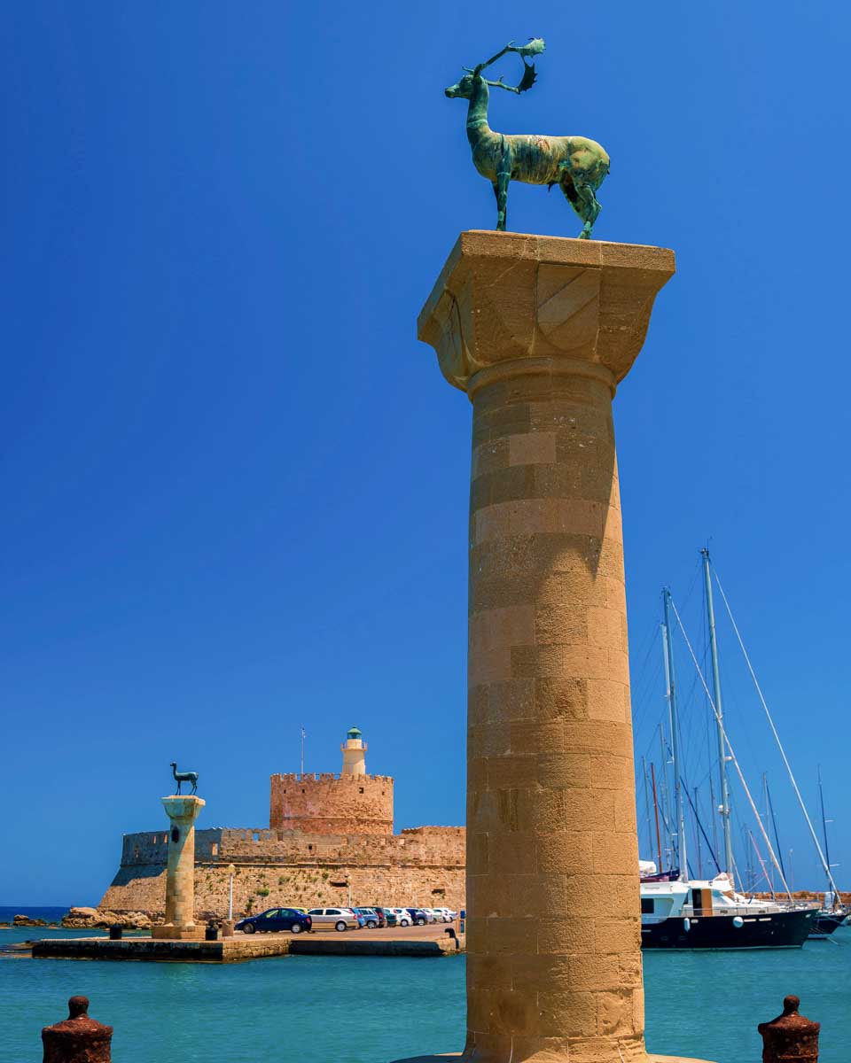 Statues-stand-either-side-of-Mandraki-harbour-entrance-where-colossus-of-rhodes-stood-Rhodes-Greece