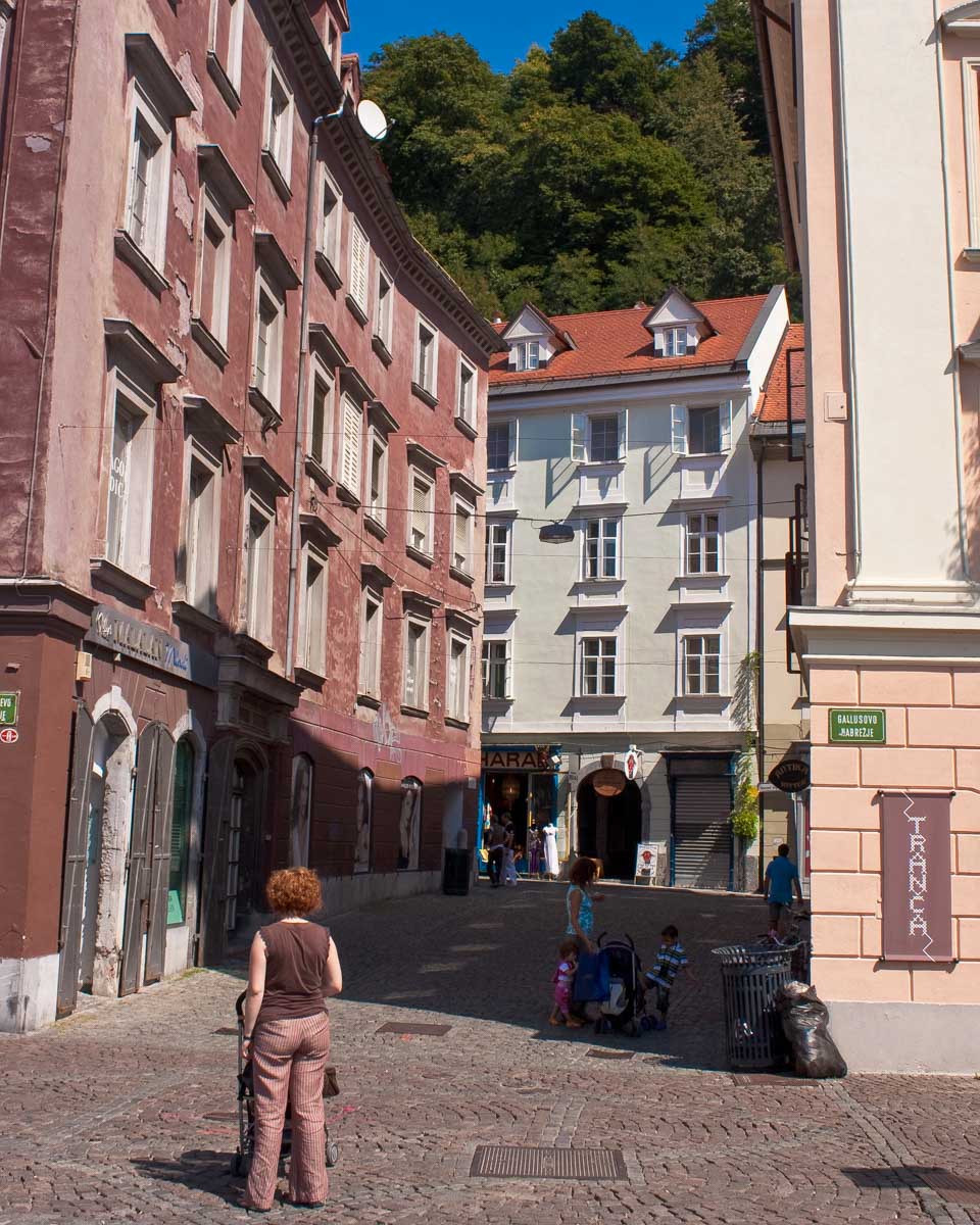 People walk through and enjoy Old Town in Ljubljana, Slovenia on a sunny day