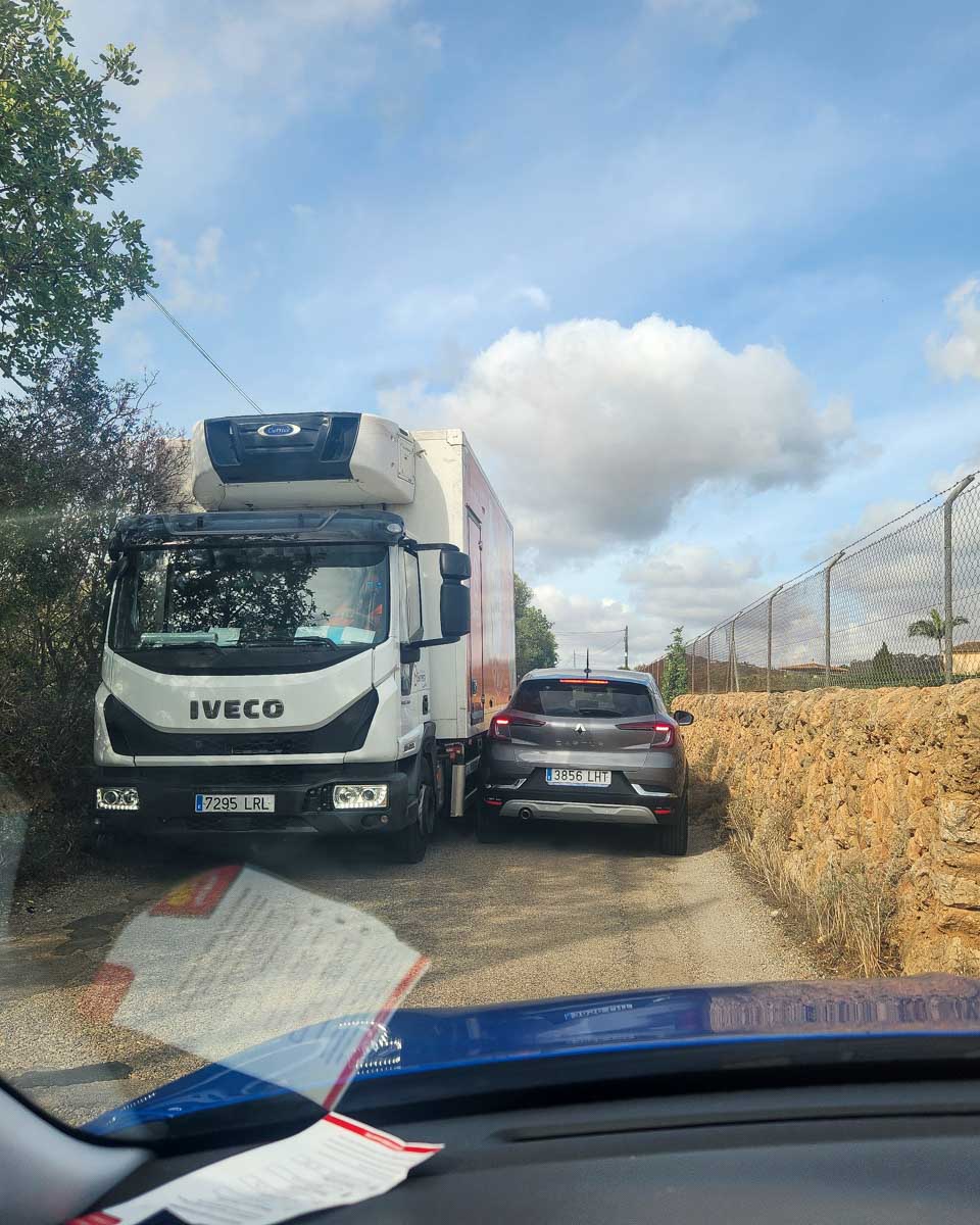 A-car-squeezes-by-a-truck-in-Italy