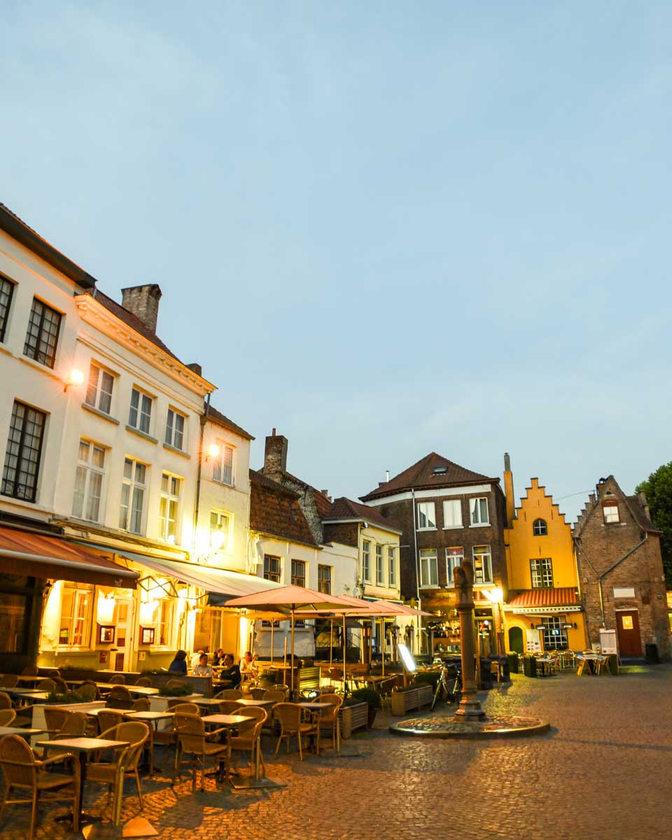 Historic Cafe Terraces in Huidenvettersplein at dusk in Bruges