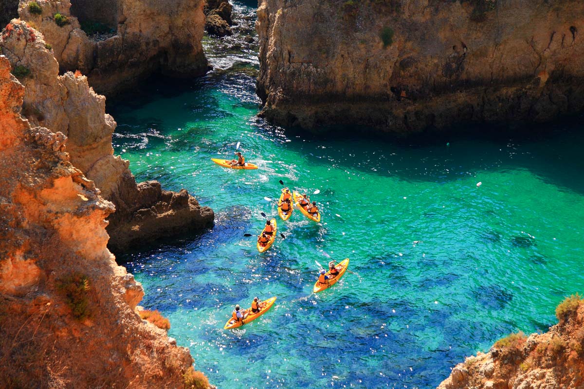 People kayak through the Ponta da Piedade rock formations in Portugal