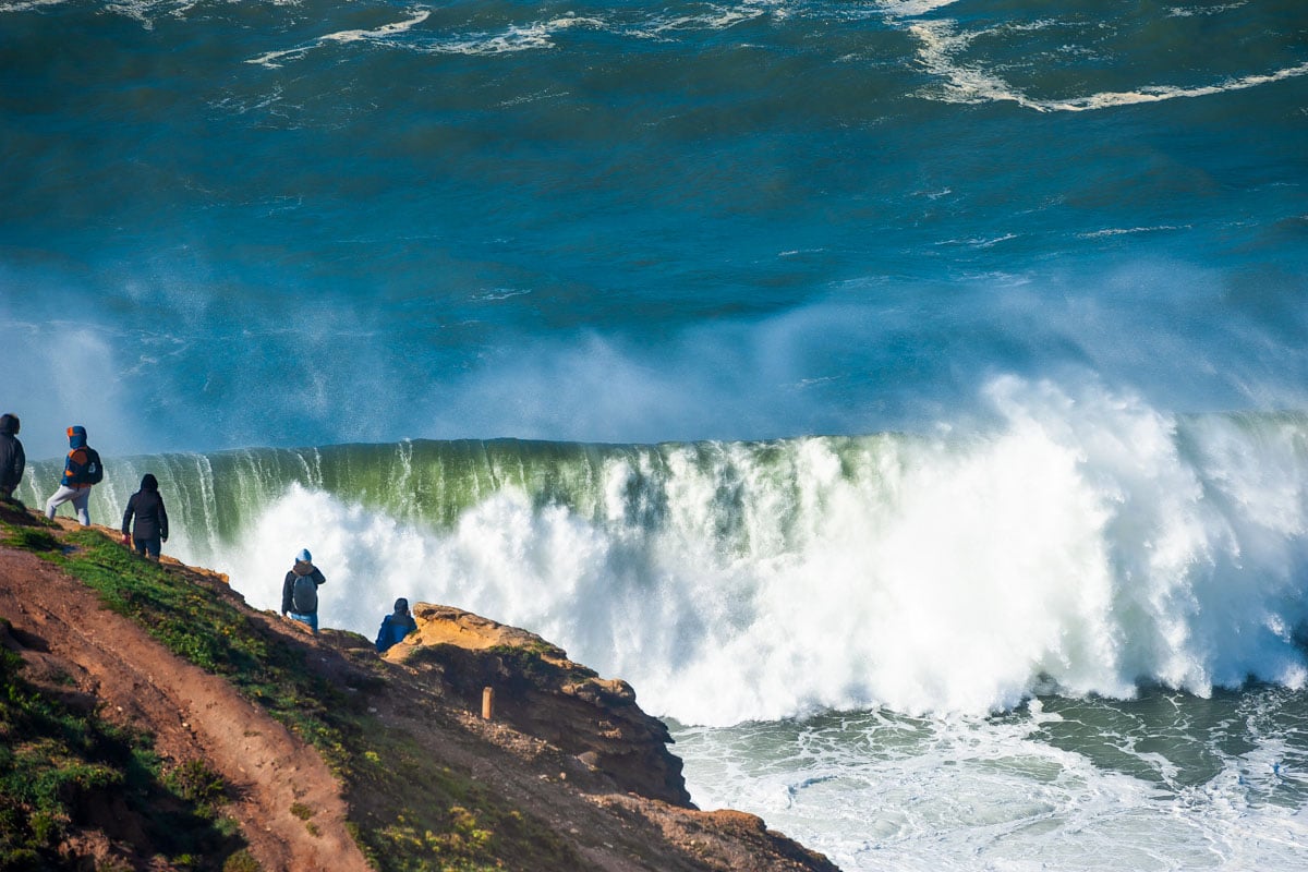 People watching big waves in Nazare, Portugal