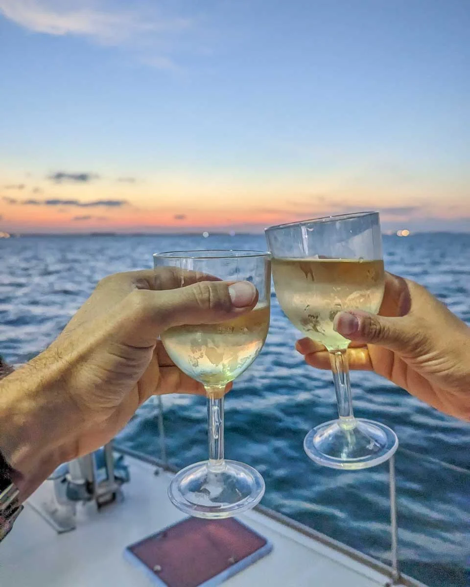 Bailey-and-Daniel-cheers-with-wine-at-sunset-on-a-cruise-in-Marbella Spain