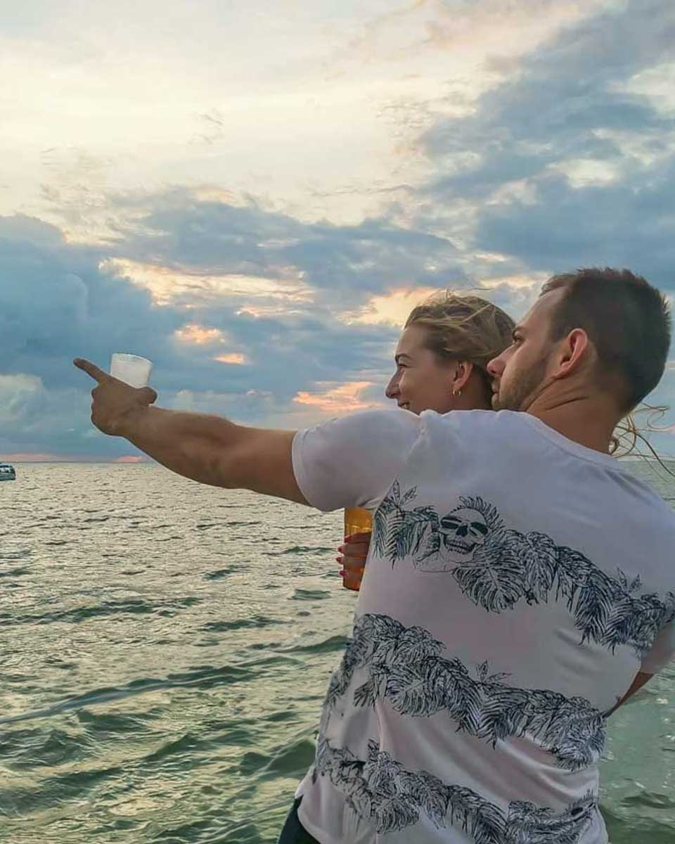Daniel-points-to-something-while-on-a-sunset-cruise-in-Cyprus