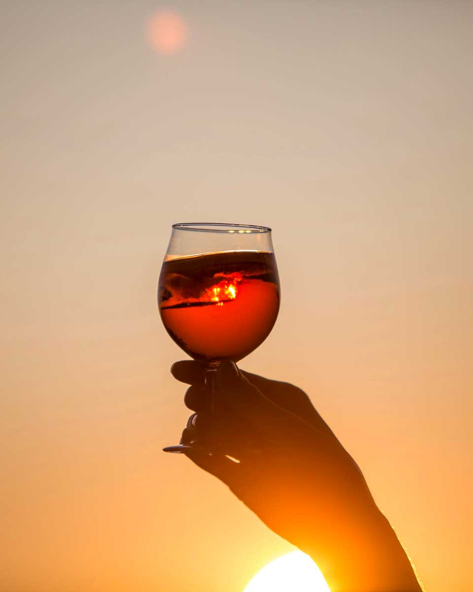 A peerson holds an aperol spritz at sunset in Zadar Croatia